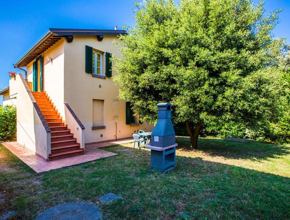a house with a tree and a blue object in the yard at Podere Simonetta - A9 in Cecina