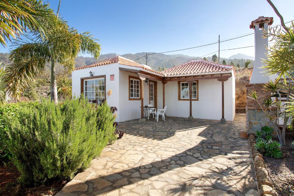 a small white house with a palm tree at Casita Ariadna in Tijarafe