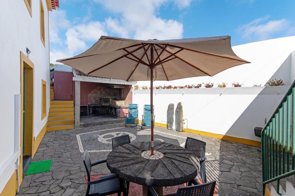 a table with an umbrella on a patio at Casa do Largo - Acores in Ponta Delgada