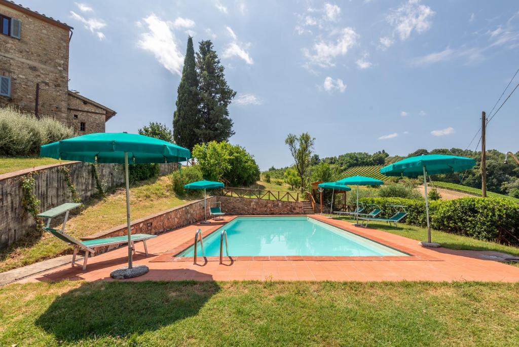 a swimming pool with two green umbrellas at Pietraserena - San Gimignano in San Gimignano