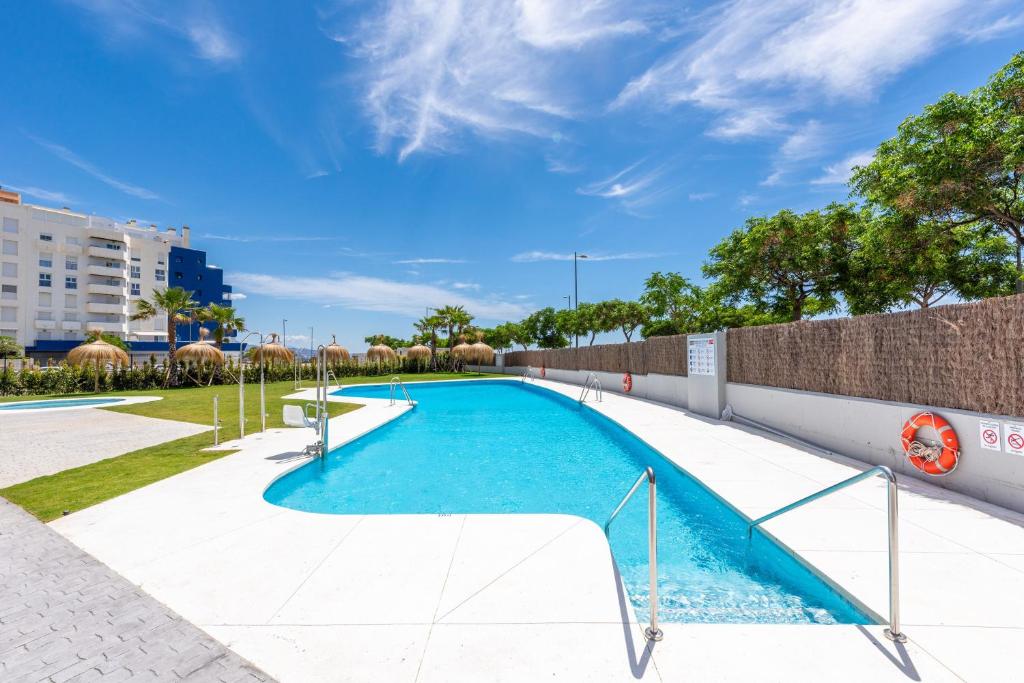 a swimming pool with blue water in a building at Adhara - 034 in Torre del Mar