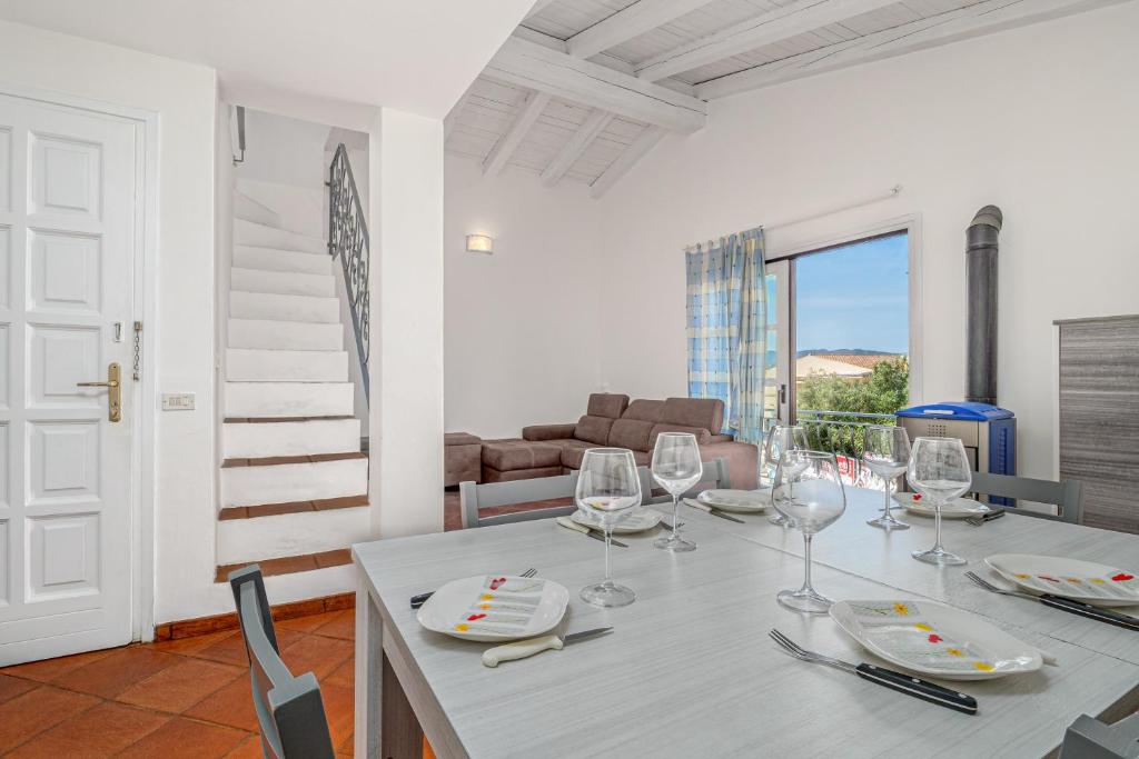 a dining room with a table with wine glasses at Trilo Piazzetta Garden in San Teodoro