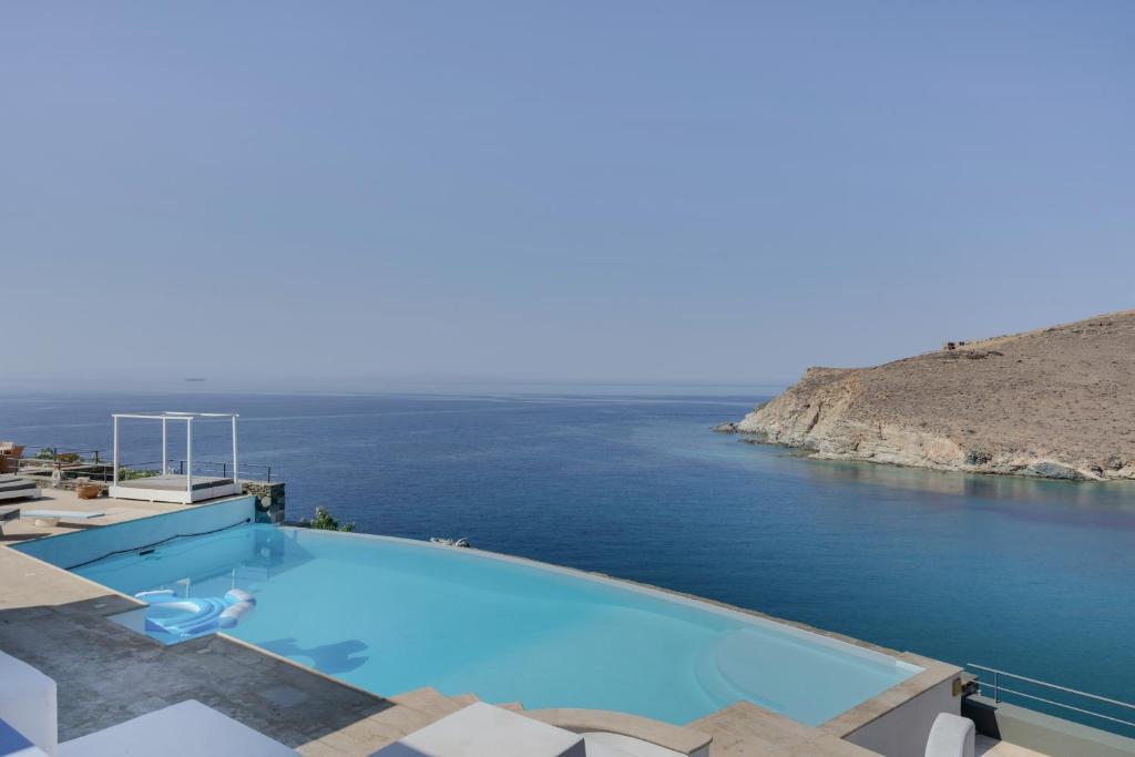 a swimming pool with a view of the ocean at Blueros - Grey Suite in Megas Gialos - Nites