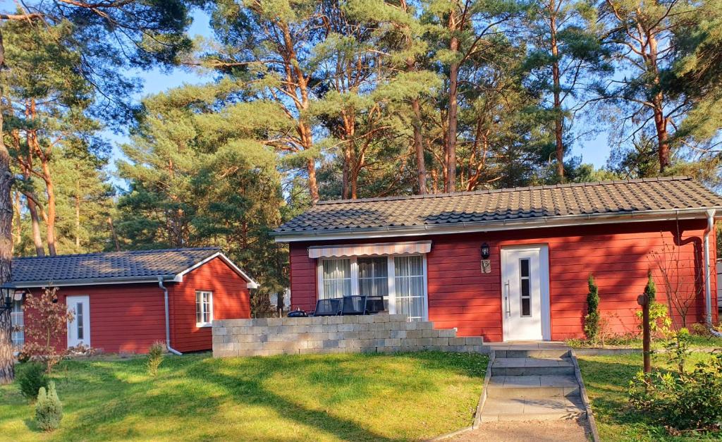 a red tiny house in a yard at Ferienhaus Specht in Zossen