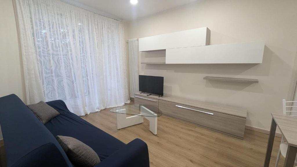 a living room with a blue couch and a tv at Casa Nicla in Colico