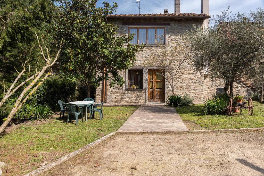 a stone house with a table in the yard at Agriturismo Il Ponte - Frantoio in Vicchio