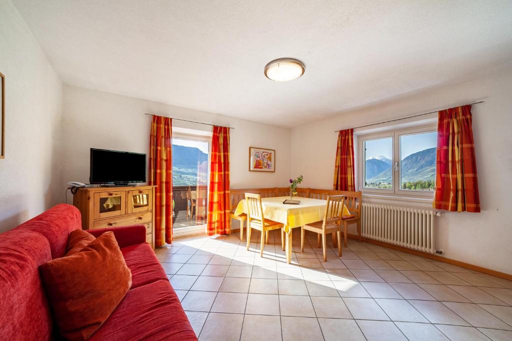 a living room with a couch and a table at Gasserhof Ferienwohnung Edelrot in Caines