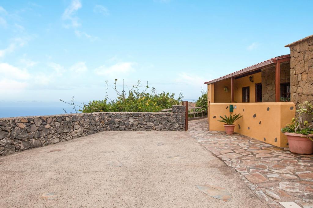 a house with a stone wall and a patio at Casa Chinamada in Las Lagunas