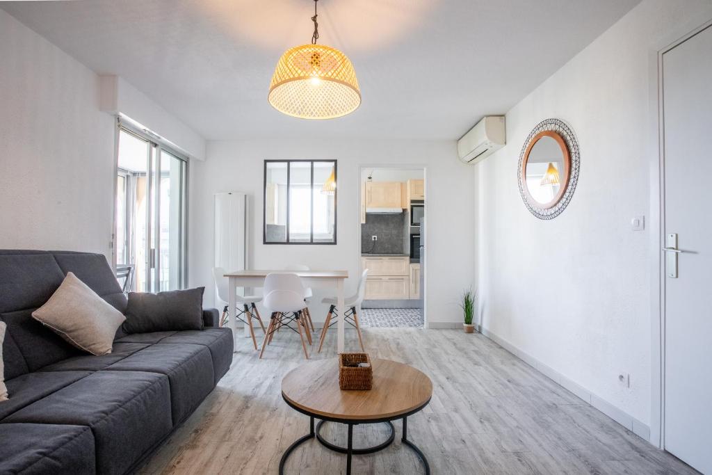 a living room with a couch and a table at Cocooning proche plage in Fréjus