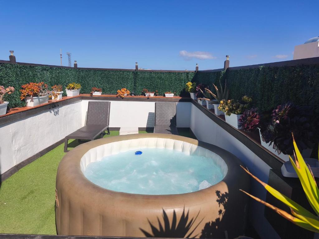 a hot tub on a balcony with plants at Casa Orymar in El Cotillo