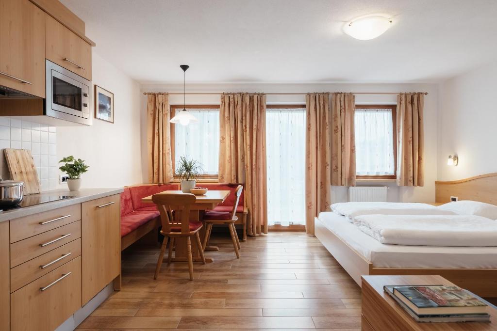 a hotel room with a bed and a table at Ciasa Willy App Lavarella in La Villa