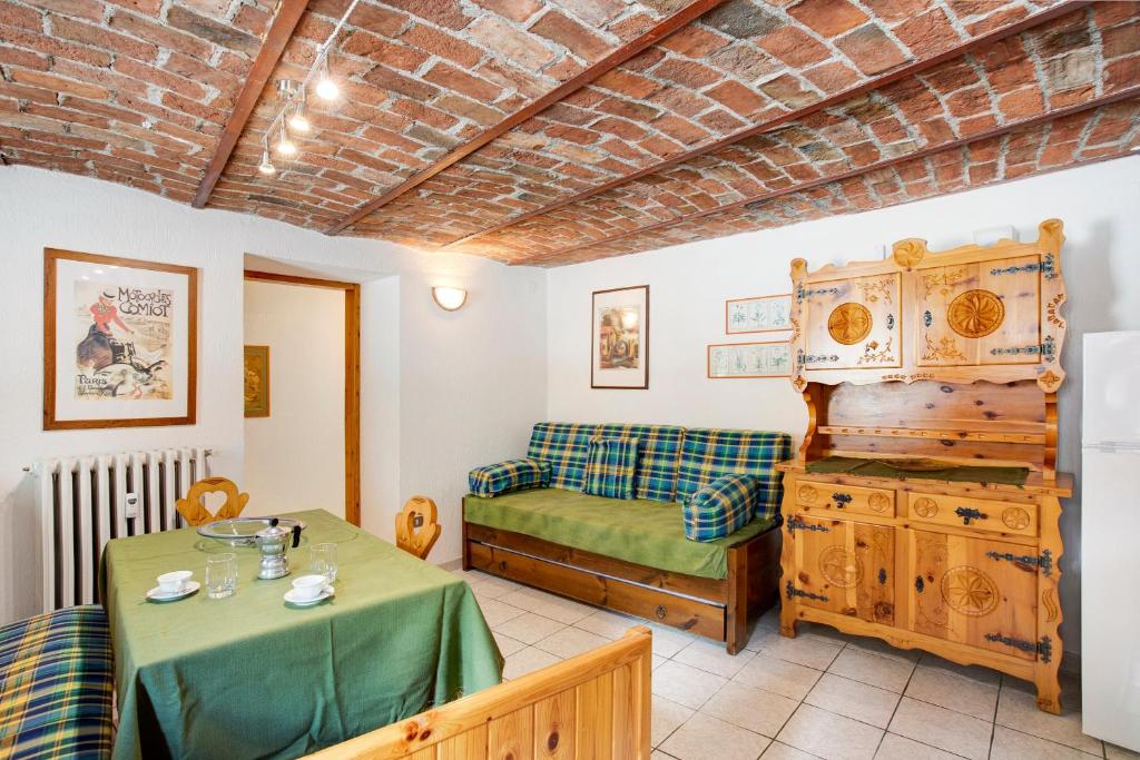 a room with a table and a bed and a couch at Maison Jaccod_piano terra in Morgex
