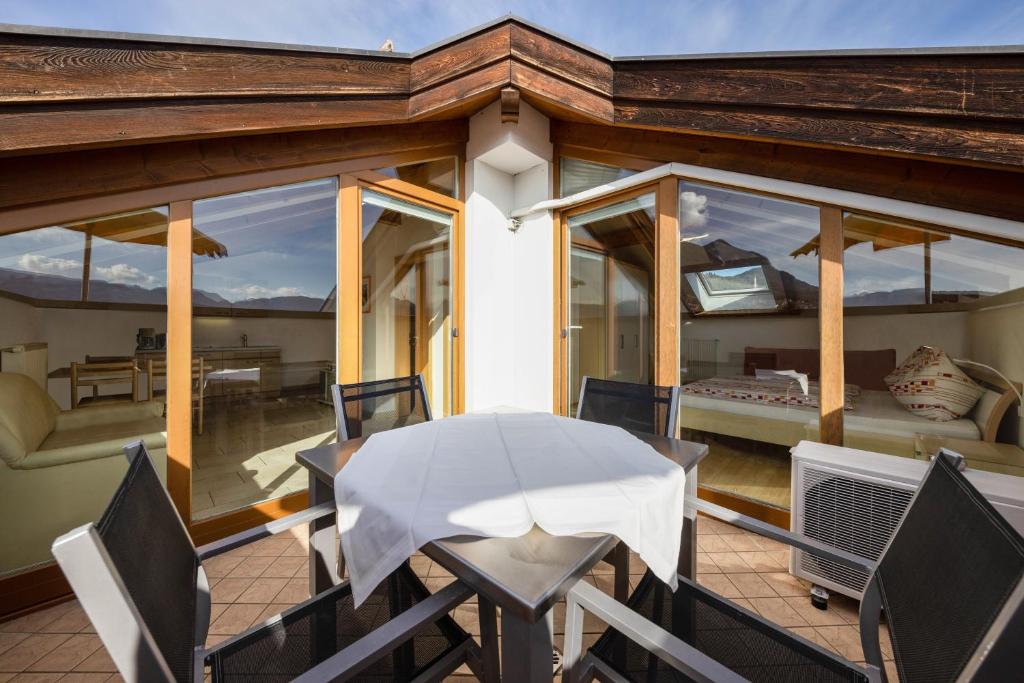 a balcony with a table and chairs on a house at Stompferhof Mansarde in Caldaro