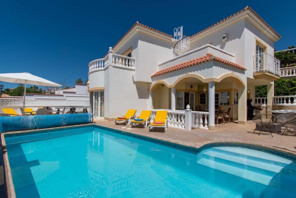 a villa with a swimming pool in front of a house at Villa Encantada in Arona