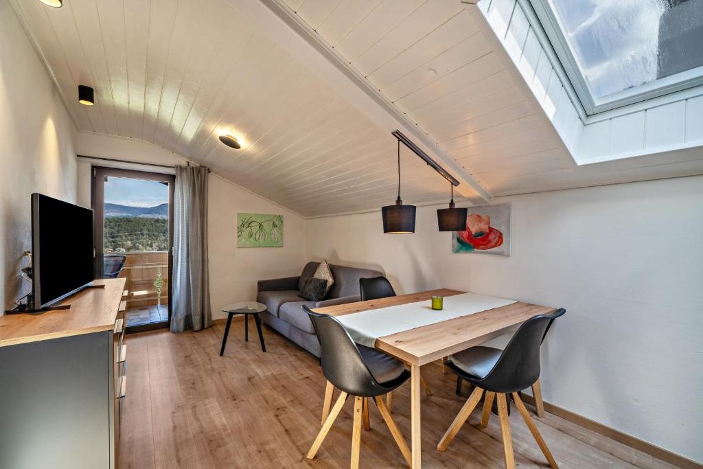 a kitchen and living room with a table and chairs at Residence Kronstein - Fewo 9 in Tesimo