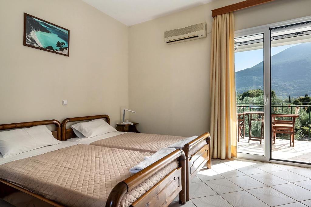 a bedroom with a bed and a large window at Daratos studio 2 in Kefallonia