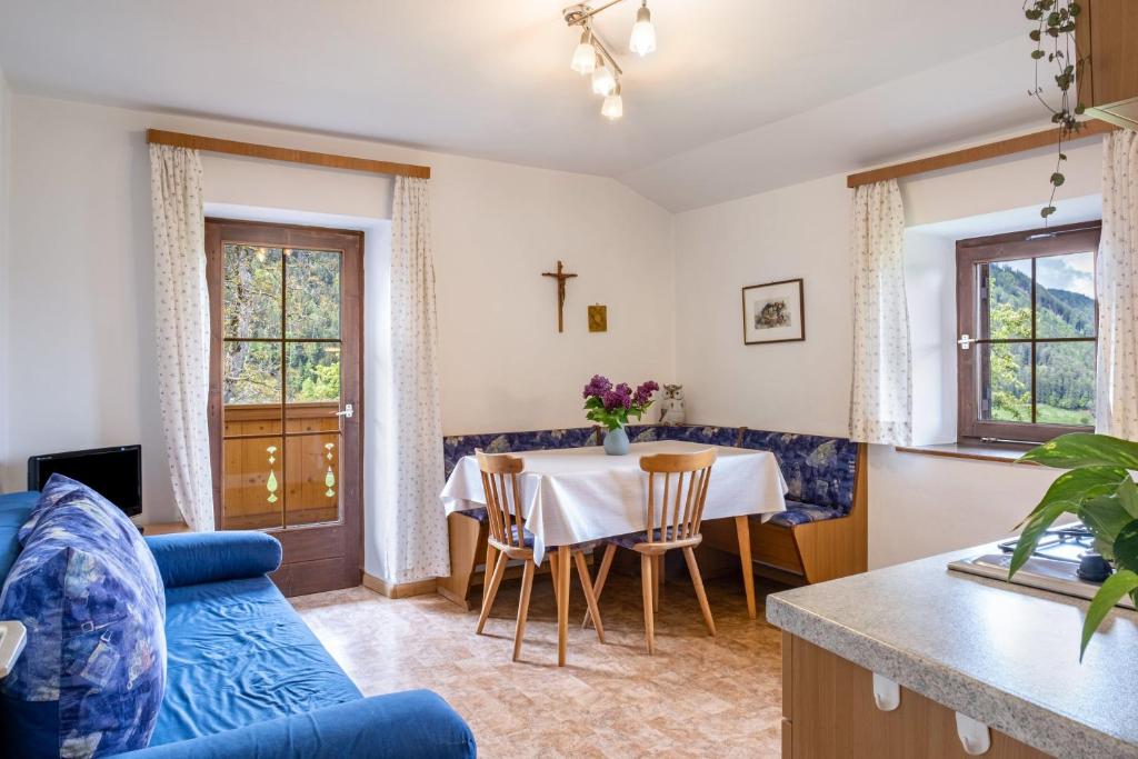 a living room with a table and a blue couch at Stablerhof Apt Löwenzahn in Cornedo all'Isarco