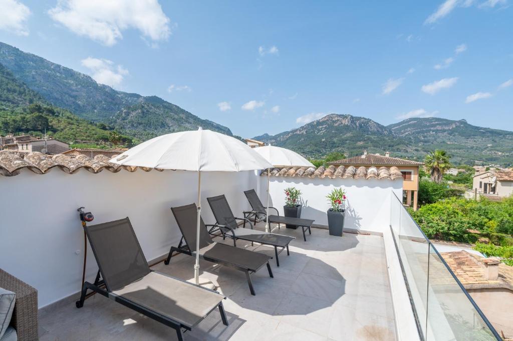 a patio with chairs and an umbrella on a roof at S'alqueria in Sóller