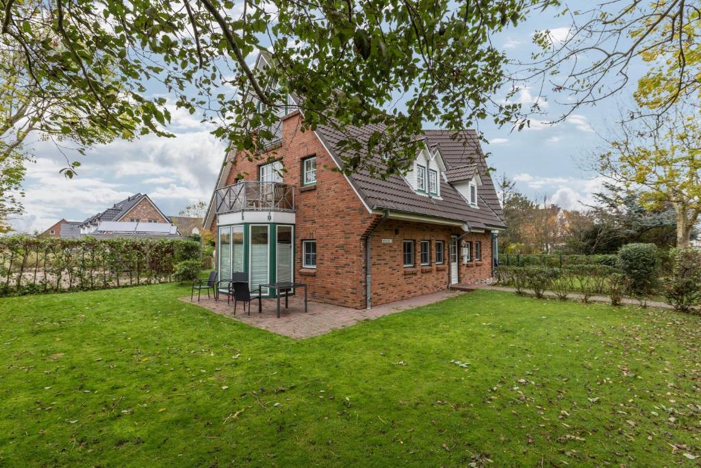 a large brick house with a lawn in front of it at Ferienwohnung Ulstrup in Böhl