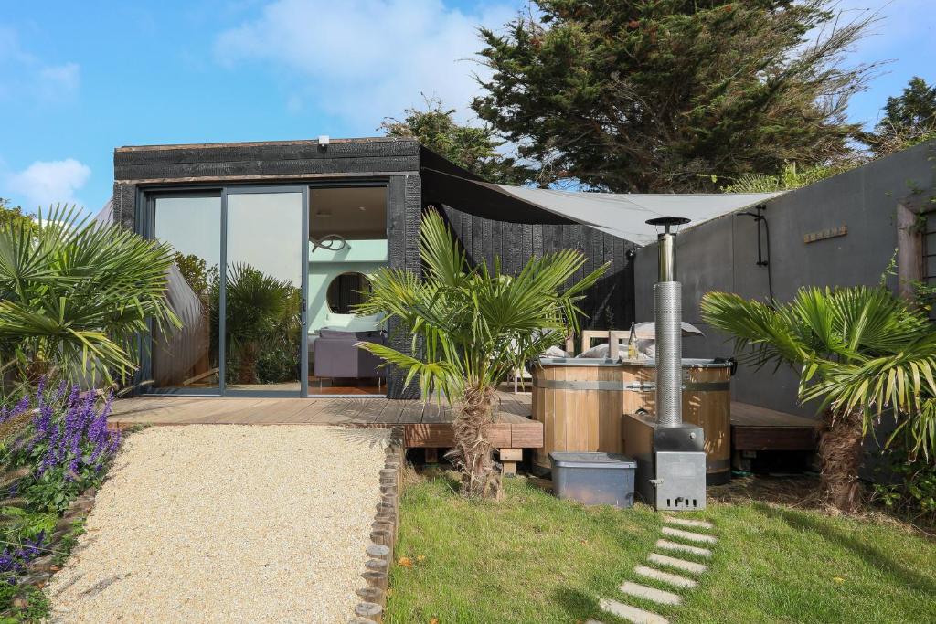 a tiny house with a front yard with palm trees at Ecolodge à 300m de la plage in Pléneuf-Val-André