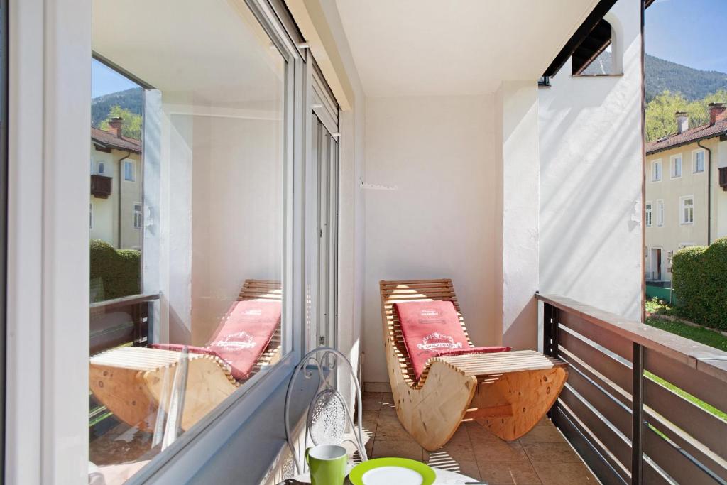 a balcony with two chairs and a large window at Berghex in Garmisch-Partenkirchen