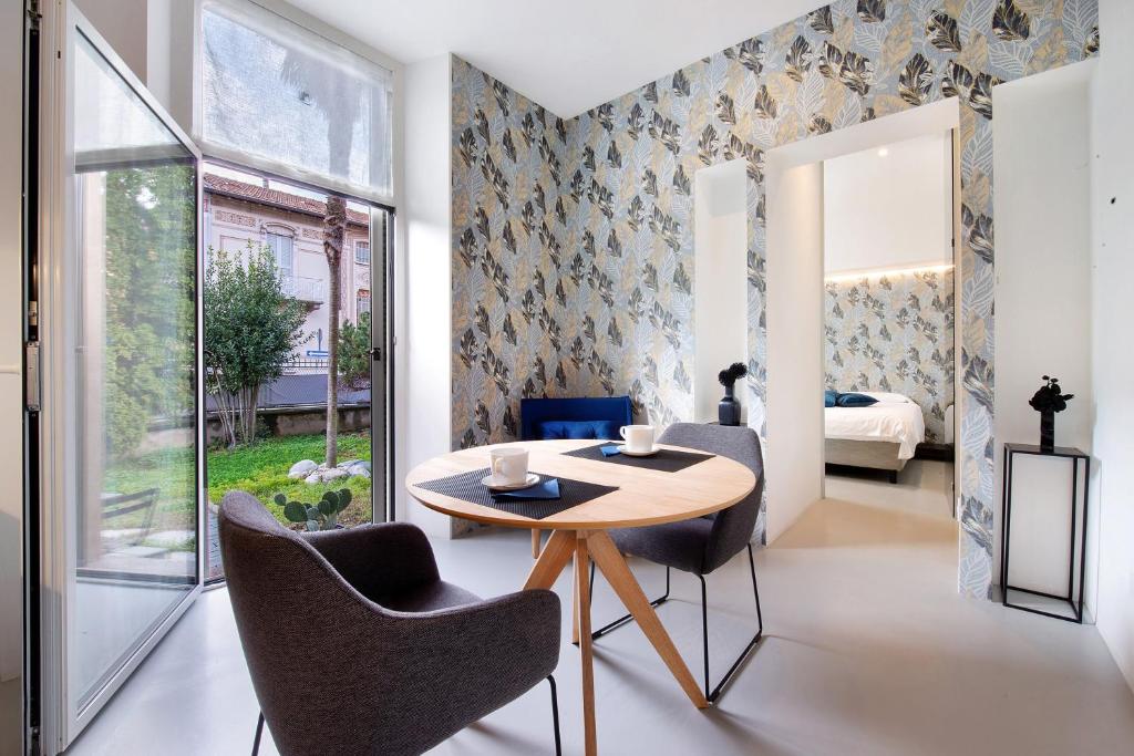 a dining room with a table and chairs and a bedroom at Lierna amorevole dimora in Lecco in Lecco
