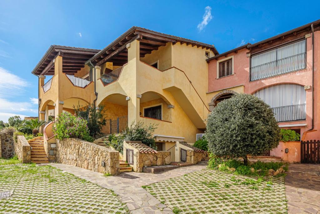 a large house with a stone pathway in front of it at Residence Orizzonti app n 3 in Golfo Aranci