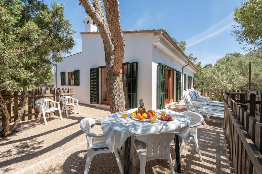 a table with fruit on it on a patio at Es Jaç in Cala Llombards