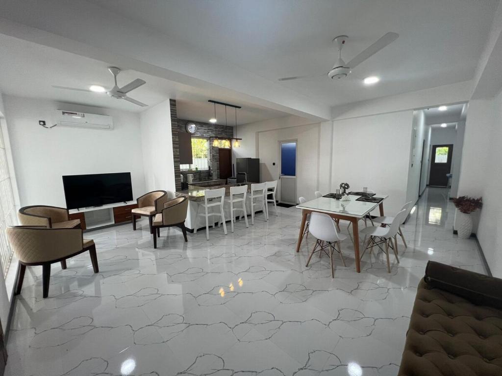 a living room with a table and chairs and a kitchen at Luxe Mini-Suite Maharagama in Maharagama