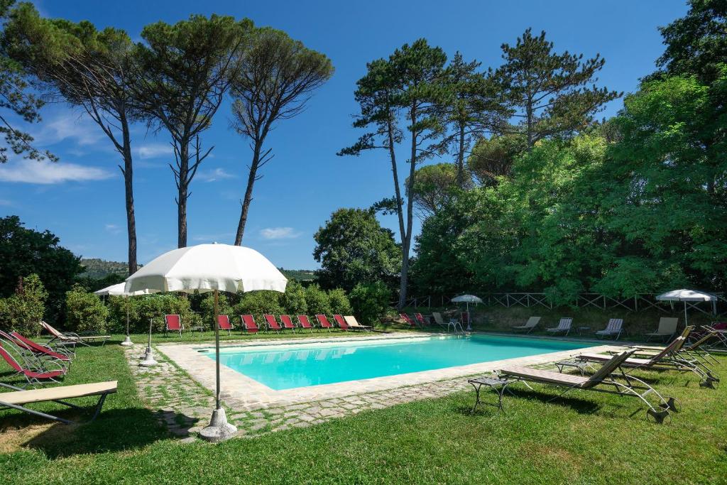 a swimming pool with chairs and an umbrella at Castello di Magrano in Gubbio