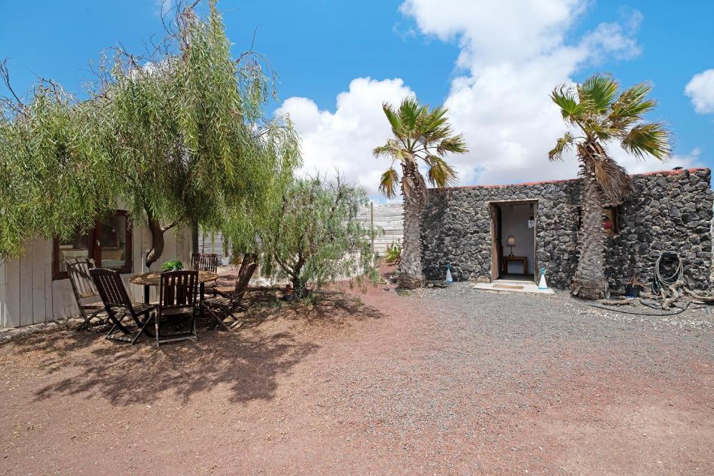 a table and chairs in front of a stone house at Aloe Art in Teguise