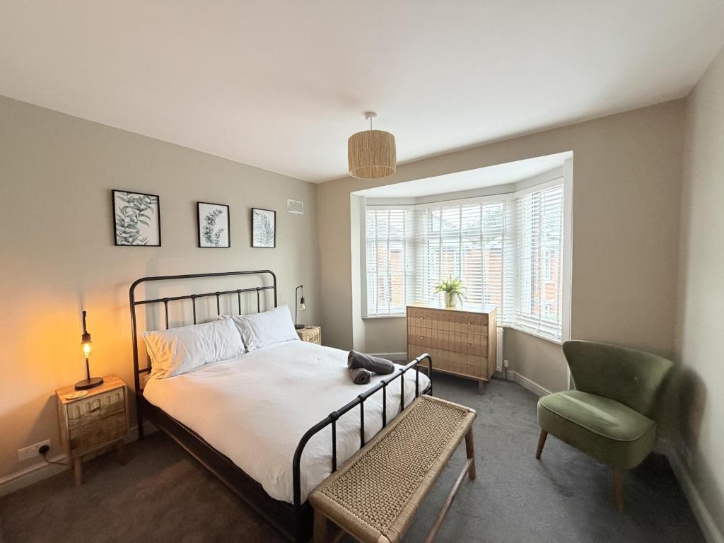 a bedroom with a bed and a chair and a window at The Hideout in Southampton