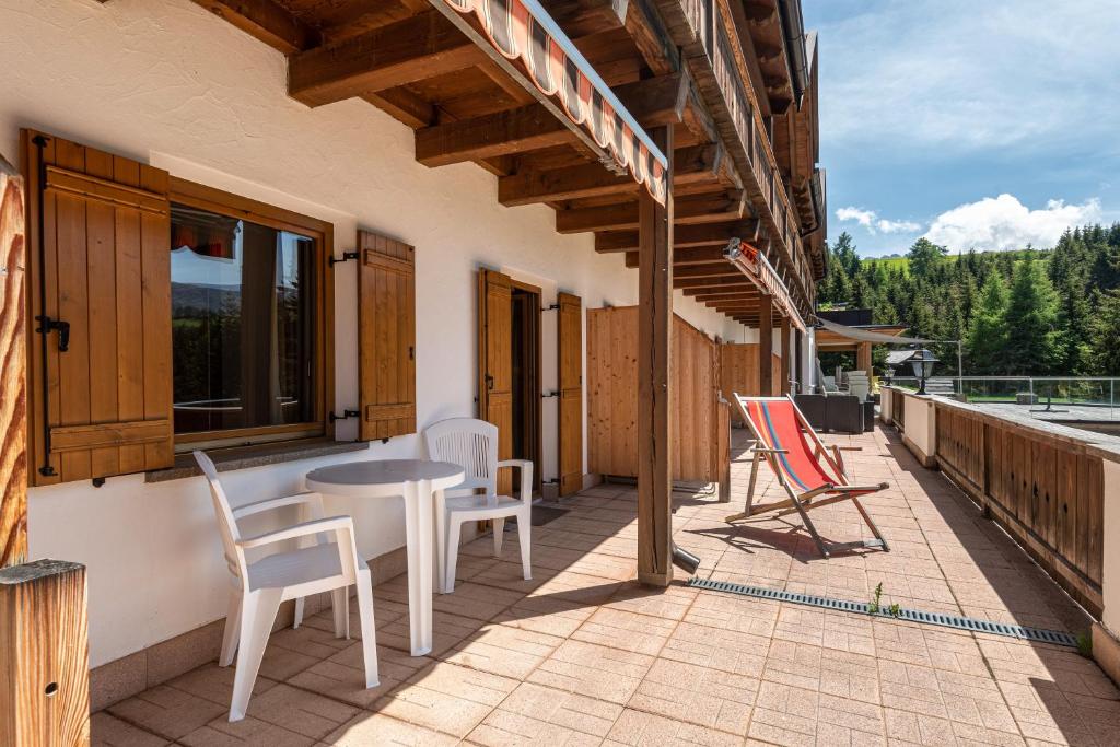 a patio with chairs and a table on a balcony at Sabina Dolomites Joch in Alpe di Siusi