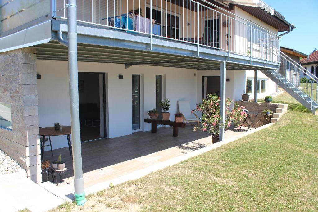 a porch of a house with a deck at Ferienwohnung Gartenblick in Herdwangen-Schönach