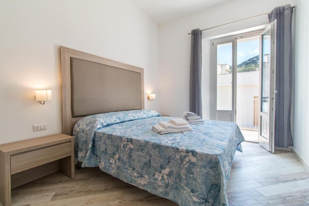 a bedroom with a bed and a large window at Appartamento Blu in Dorgali