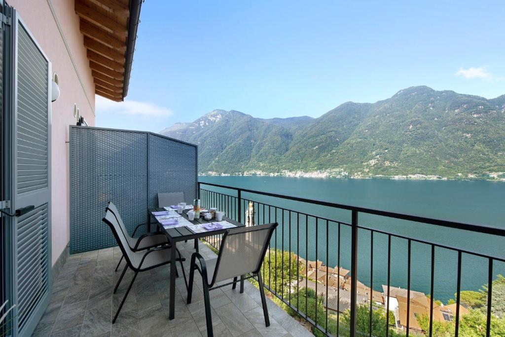 a table and chairs on a balcony with a view of the water at Appartamento 7 Il Tornante in Nesso