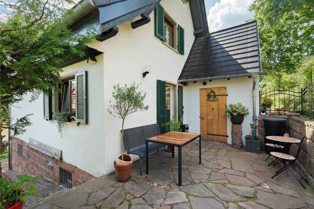 a patio with a wooden table in front of a house at Haus Schwarzwald Königin in Bühlertal