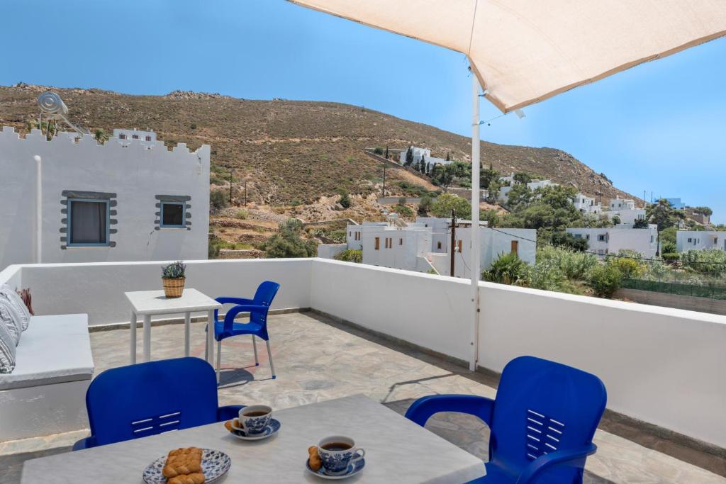 a patio with blue chairs and tables on a balcony at Pico Bello Patmos 16 in Patmos