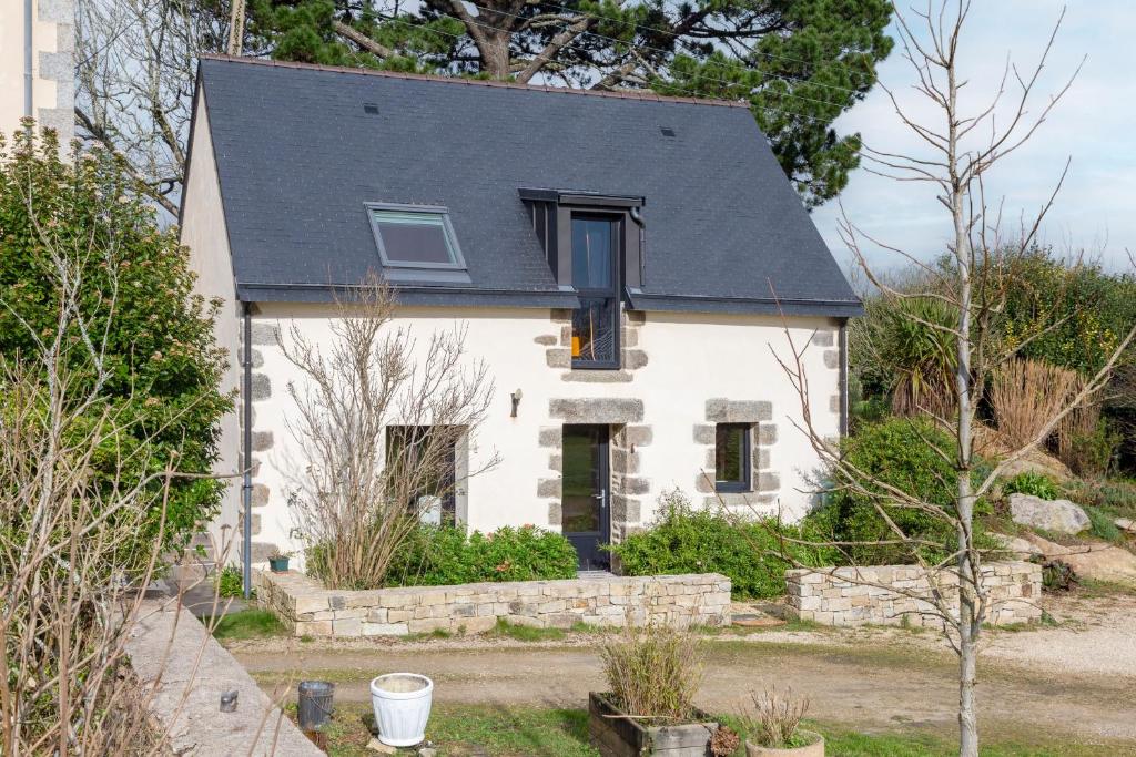 a white house with a black roof at Le Penty - proche plages et centre in Concarneau