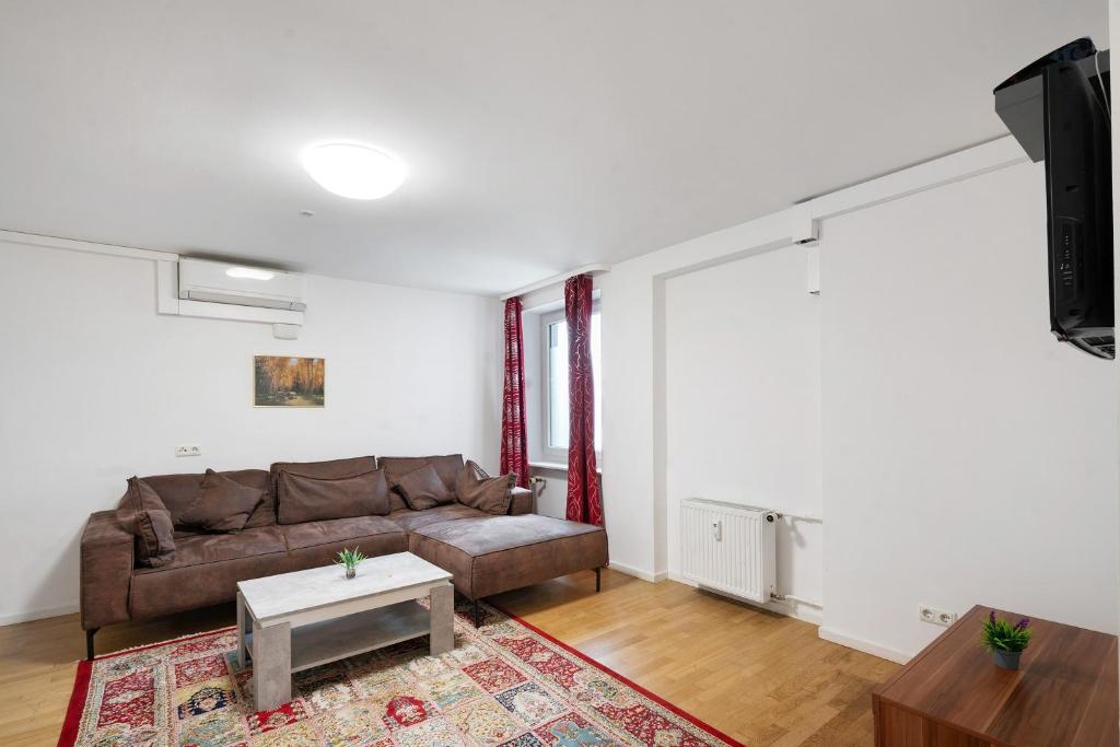 a living room with a couch and a tv at Aldars Urban Grand Suite No.15 in Munich