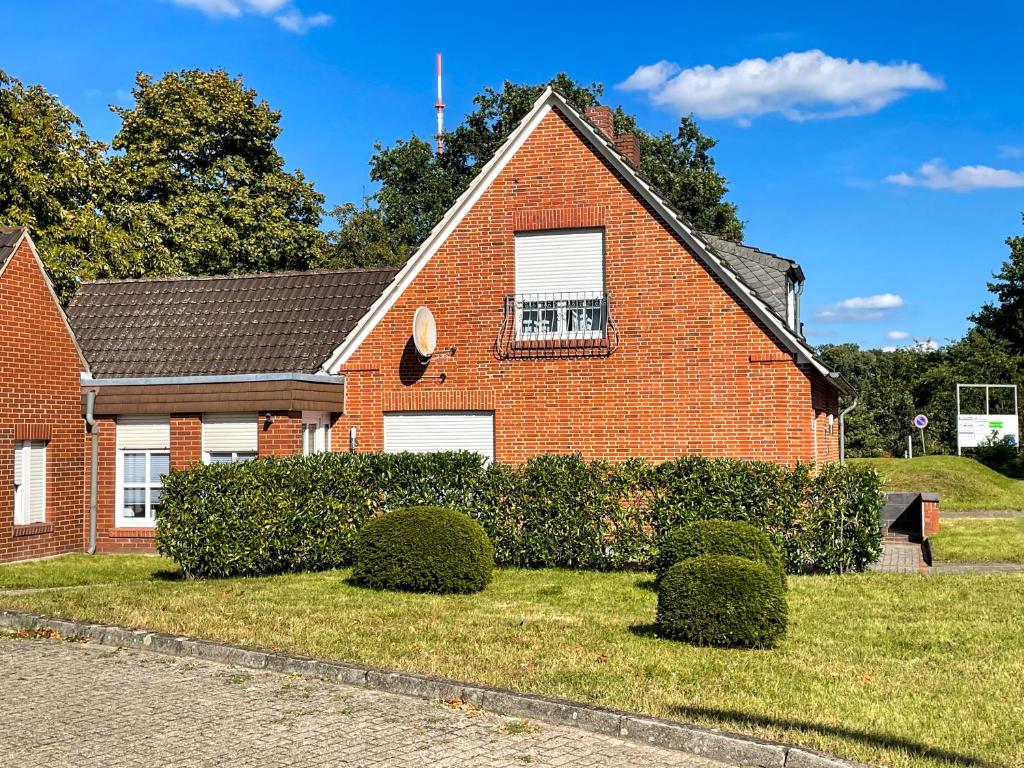 a red brick house with bushes in front of it at room4rent in Lingen