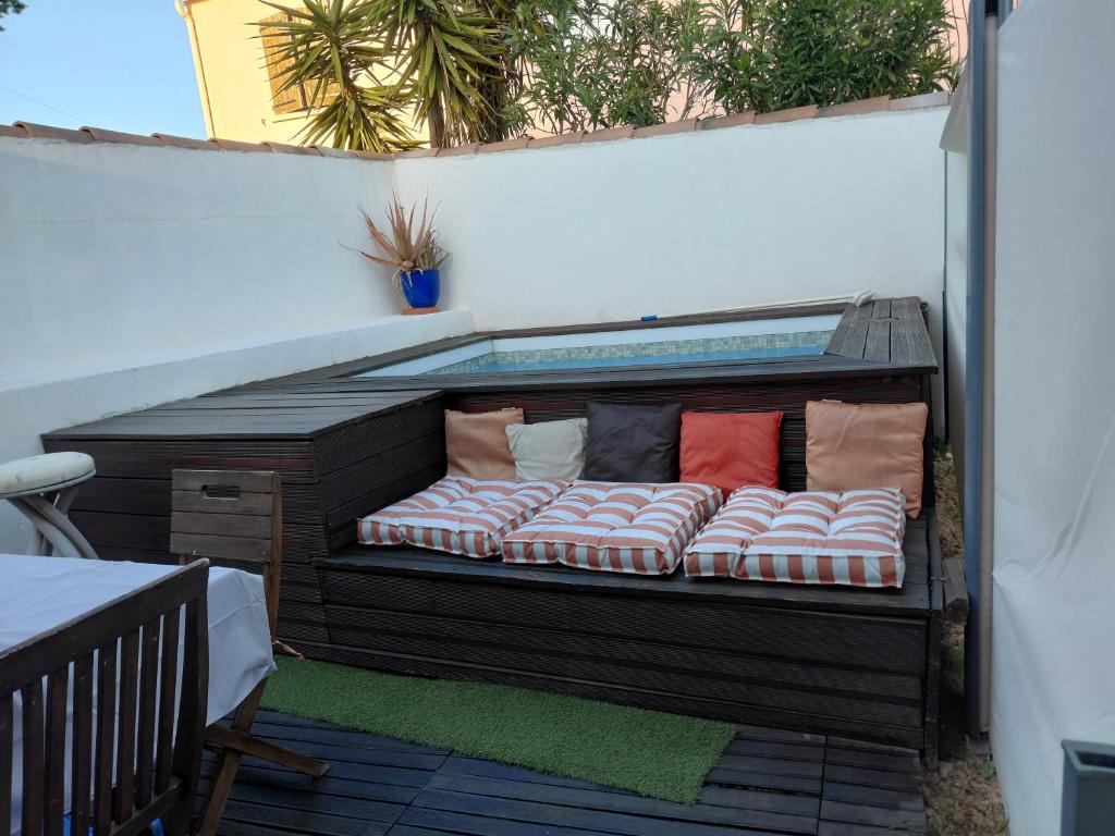 a wooden bench with pillows on a patio at Sous le soleil in Bandol