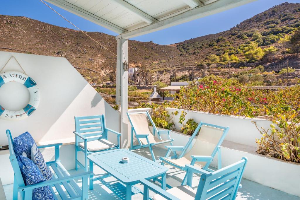 a group of blue chairs and a table on a porch at Beachfront Lampis Dolphin 3 in Skala