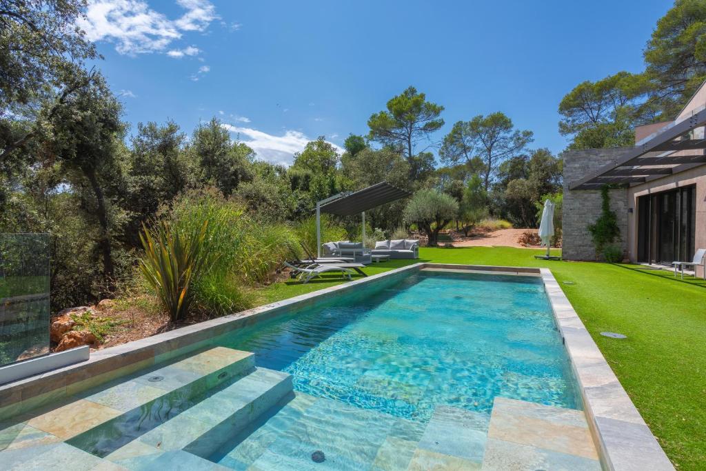 a swimming pool in the backyard of a house at Villa Valériane in Trans-en-Provence