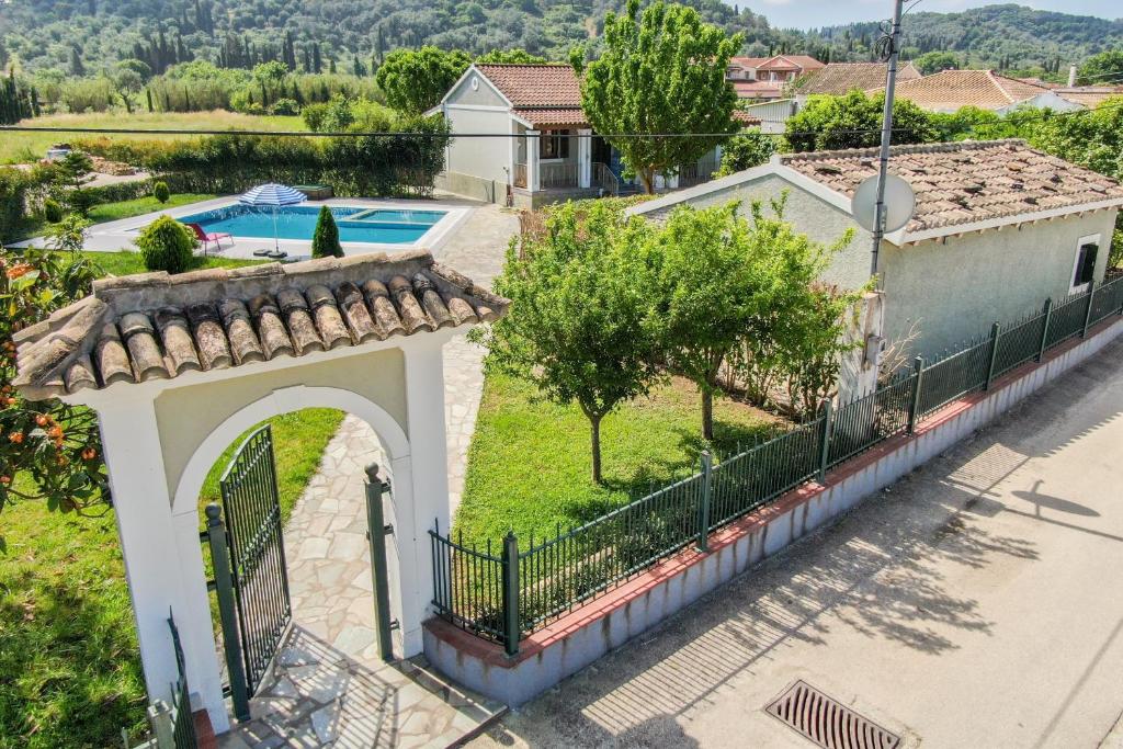 an external view of a house with a gate and a swimming pool at Mini Country House in Sidari
