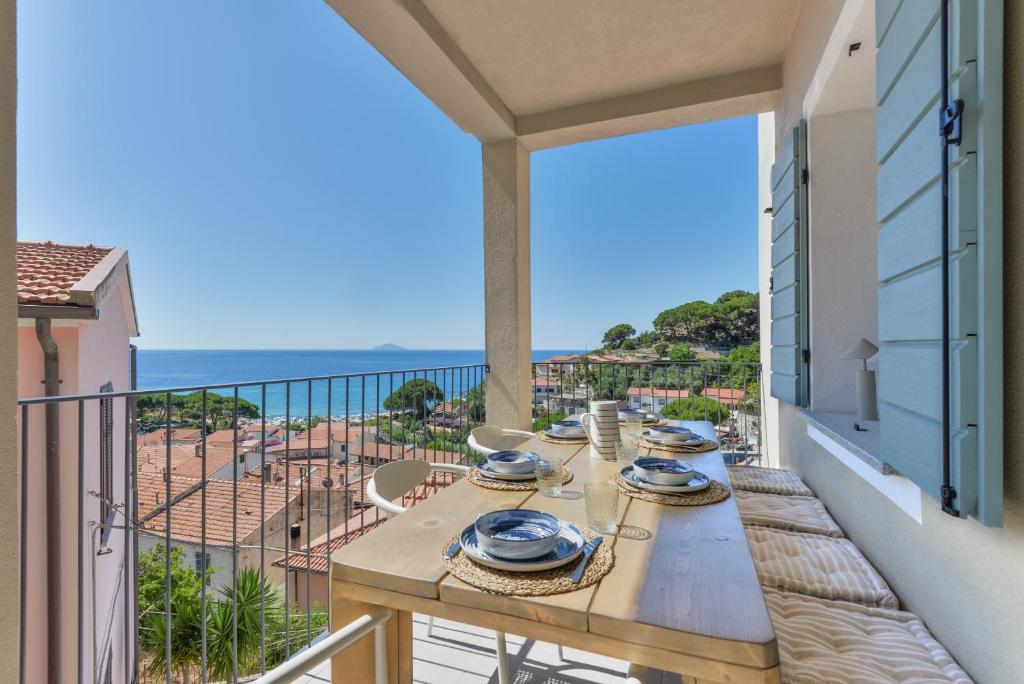 a table on a balcony with a view of the ocean at Casa Azzurrina Mare in Seccheto