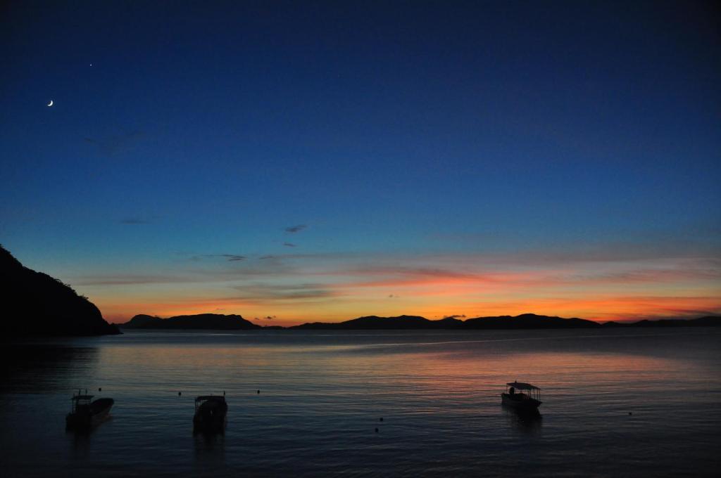 a group of boats in the water at sunset at Tokashiku Marine Villege in Tokashiki