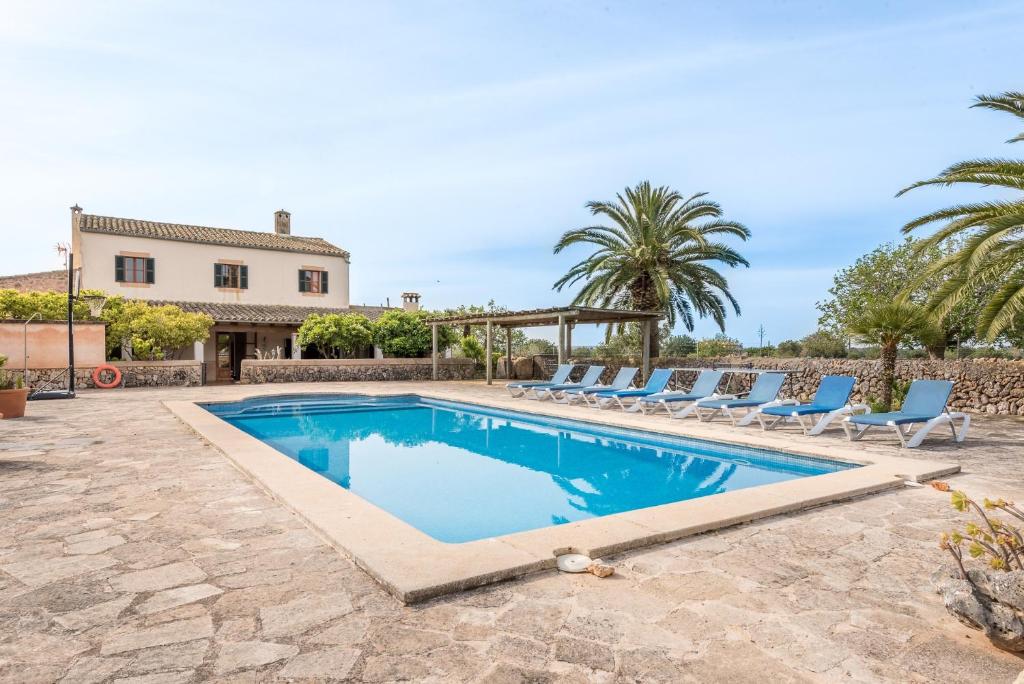 a swimming pool with chairs and a house at Son Rossinyol Nou - 12 personas in Islas Baleares