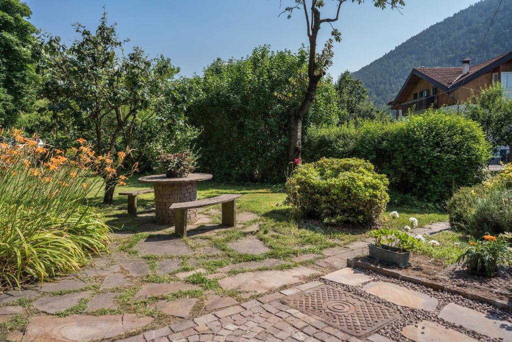 a garden with a bench and some bushes and trees at Lases Piano Terra in Albiano
