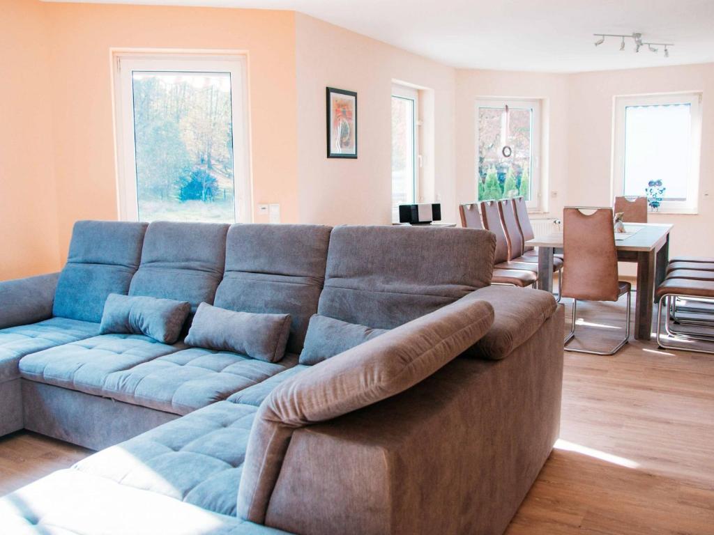 a living room with a blue couch and a dining room at Ferienhaus Paula in Olsberg